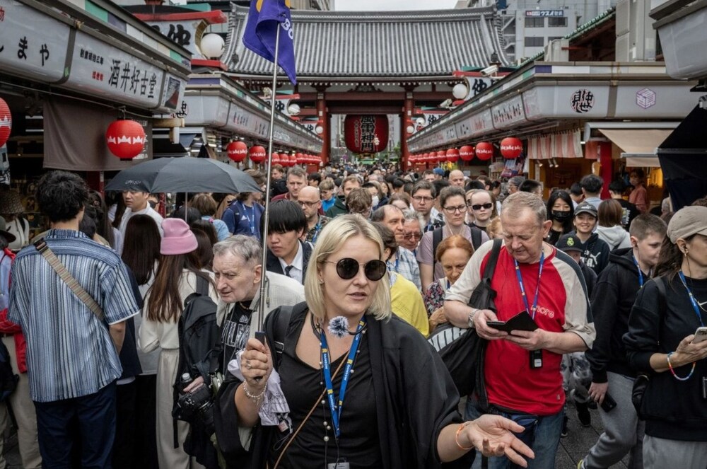 Khách du lịch đi bộ qua phố mua sắm Nakamise gần chùa Sensoji ở Tokyo vào ngày 30/4/2024 - Ảnh: afp.com