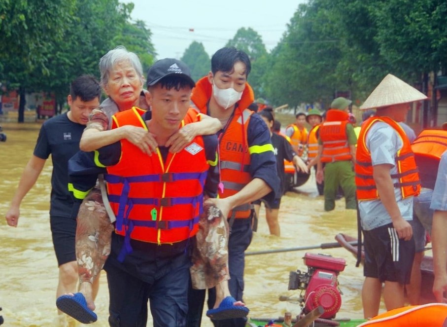 Lực lượng chức năng hỗ trợ đưa người dân vùng ngập đến nơi an toàn - Ảnh: AN NINH THÁI NGUYÊN