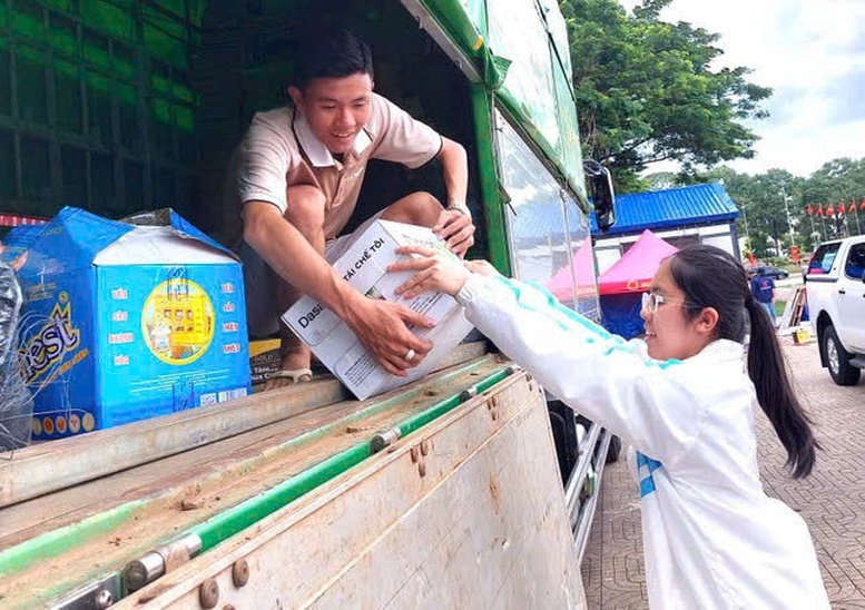 Em Đặng Phan Diễm Quỳnh, học sinh lớp 10 của Trường THPT Buôn Ma Thuột vận chuyển hàng hóa lên xe - Ảnh: Báo Tiền Phong