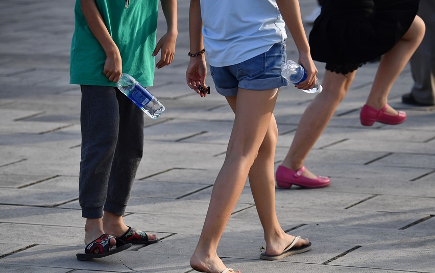 Một cô gái mặc quần soóc bò ngắn cũn cỡn, chân đi dép tông.
