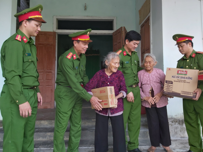 Thượng tá Trần Phúc Thịnh, Trưởng phòng CSMT tỉnh Nghệ An trao quà hỗ trợ người dân vùng lũ Hà Tĩnh.