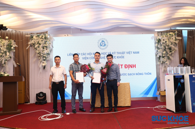 Ông Lê Hữu Thị - Viện trưởng và Nhà báo Trần Văn Chung - Phó Viện trưởng trao quyết định và tặng hoa chúc mừng đại diện ban quản lý dự án Nước sạch Nông thôn.