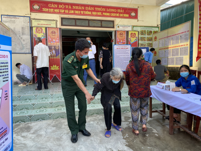 Một đồng chí Bộ đội dìu cử tri Đào Thị Nuôi ( 90 tuổi) đến bầu cử tại thôn Long Hải, Thạch Kim, Lộc Hà