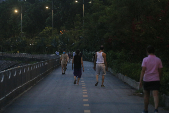 Lúc gần 19h dọc tuyến đường đi bộ cạnh sông Tô Lịch, đông đảo người dân vẫn vô tư tập thể dục dù lực lượng chức năng dựng rào chắn, treo băng-rôn tuyên truyền
