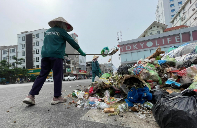 Nhân viên vệ sinh môi trường gom rác rồi đổ tập kết tại ngã tư khu phố