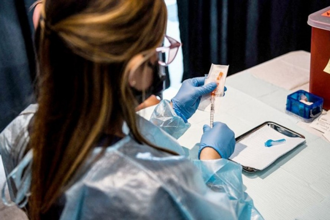 Nhân viên y tế chuẩn bị vaccine COVID-19 để tiêm tại điểm tiêm chủng ở Miami, Mỹ. Ảnh: AFP