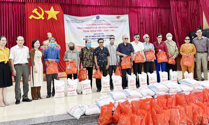 Lãnh đạo Hội Bảo trợ NKT-TMC tỉnh cùng đại diện nhà hảo tâm trao tặng radio và quà cho người khiếm thị trên địa bàn TX Đông Triều. Ảnh: BQN