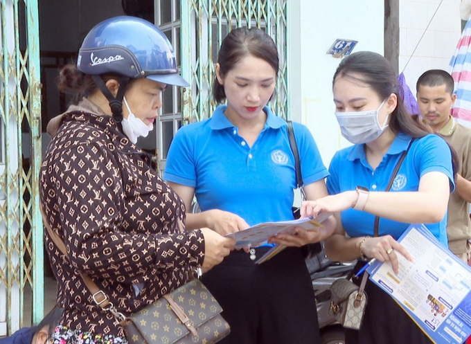 Cán bộ BHXH huyện Tiên Yên hướng dẫn cho người dân về những lợi ích khi tham gia BHXH tự nguyện. Ảnh: BQN