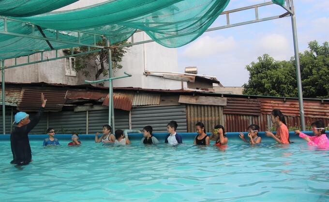 Giáo viên hướng dẫn kỳ năng bơi lội cho các em tại lớp học. Ảnh: BĐL