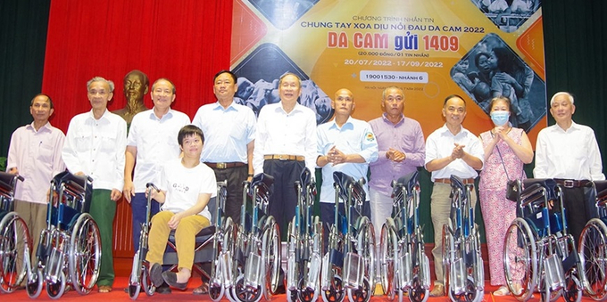 Thượng tướng Nguyễn Văn Rinh, Chủ tịch Hội Nạn nhân chất độc da cam/dioxin Việt Nam (đứng thứ năm, từ trái sang) trao xe lăn tặng các nạn nhân da cam