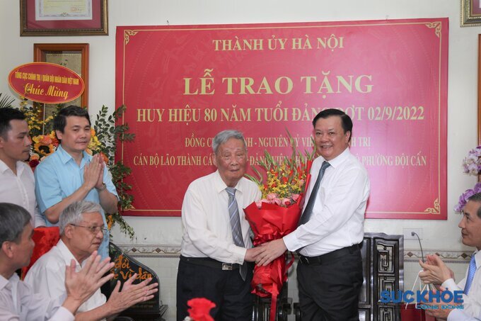 Bí thư Thành ủy Hà Nội Đinh Tiến Dũng tặng hoa, chúc mừng đồng chí Vũ Oanh