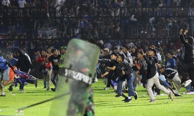 Cổ động viên tràn xuống sân vận động Kanjuruhan ở thành phố Malang, tỉnh Đông Java, Indonesia, tối 1/10, gây ra tình trạng hỗn loạn. Ảnh: AP