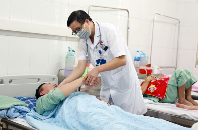 Bác sĩ Khoa Bệnh nhiệt đới thăm khám cho bệnh nhân sốt xuất huyết. Ảnh: BVCC