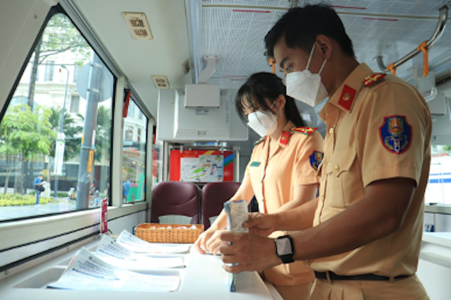 Tờ rơi tuyên truyền song ngữ Việt – Anh được đặt tại các kệ thông tin trên xe buýt
