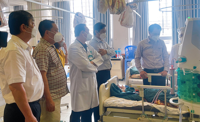 TS. BS Trần Quang Hiền, Giám đốc Sở Y tế An Giang thăm bệnh nhân bị ngộ độc chè điều trị tại Bệnh viện Đa khoa Trung tâm An Giang. Ảnh: BAG