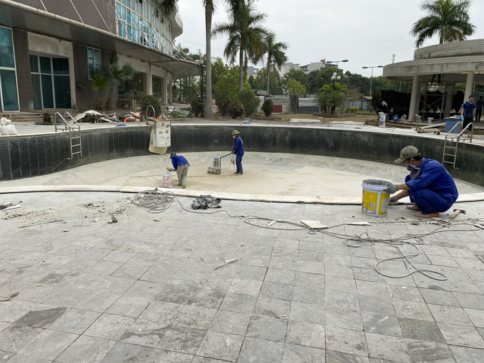 Công nhân sửa chữa, dọn vệ sinh khu vực bể bơi của khách sạn.