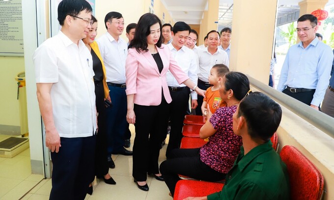 Bộ trưởng Bộ Y tế Đào Hồng Lan và các đồng chí lãnh đạo tỉnh Nghệ An thăm hỏi, trò chuyện với người dân đến khám tại Trung tâm Y tế xã Nam Thái, huyện Nam Đàn. Ảnh: Thành Duy
