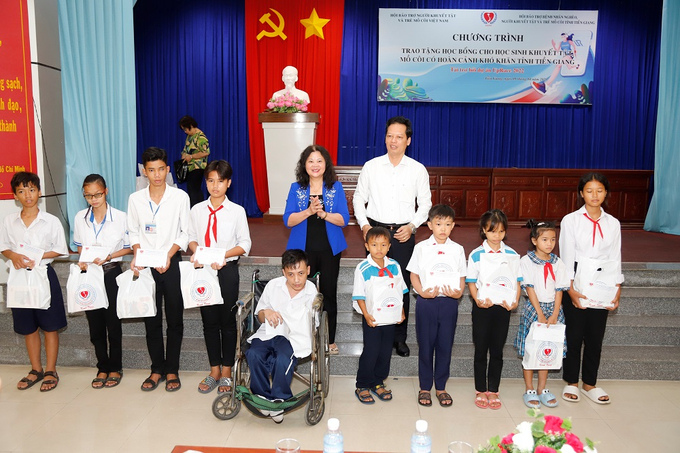 Phó Chủ tịch UBND tỉnh Nguyễn Thành Diệu và Phó Chủ tịch Hội Bảo trợ người khuyết tật trẻ mồ côi Việt Nam Trần Thị Dung trao học bổng cho HS huyện Cái Bè