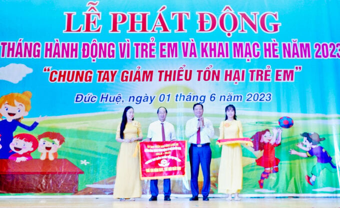 Phó Chủ tịch UBND tỉnh - Phạm Tấn Hòa (thứ 2 từ phải qua) trao cờ Phát động Tháng hành động Vì trẻ em và Khai mạc hè năm 2023 