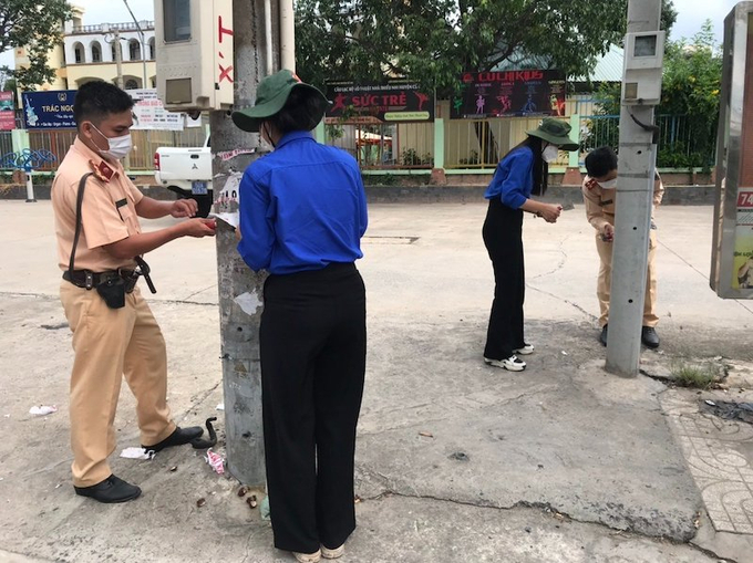 CBCS Trạm CSGT Tây Bắc phối hợp với ĐVTN tình nguyện xóa quảng cáo trên các cột điện trên địa bàn của xã Tân Thông Hội, huyện Củ Chi