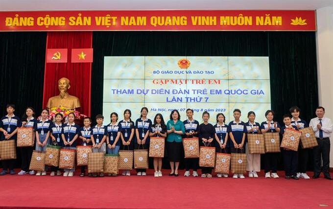 Thứ trưởng Ngô Thị Minh trao quà và chụp ảnh lưu niệm cùng đại diện các em học sinh tham dự Diễn đàn Trẻ em quốc gia 2023. Ảnh: Trung tâm truyền thông và sự kiện  