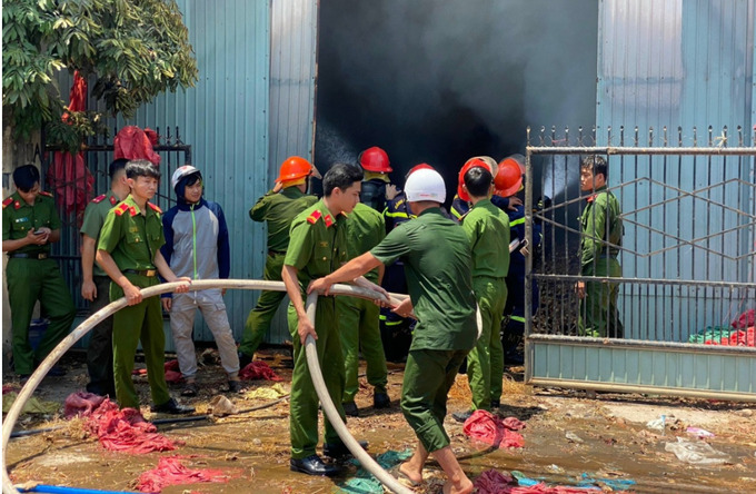 Lực lượng chức năng nỗ lực xử lý đám cháy tại kho nông sản. Ảnh: VOV