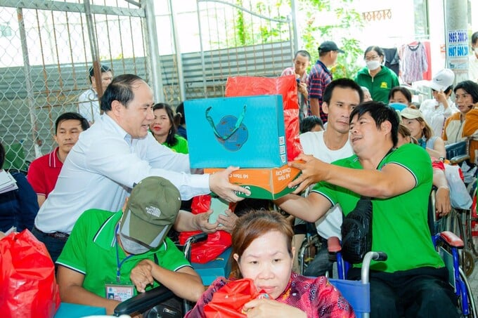 Ông Phạm Đình Vương, Trưởng văn phòng Đại diện Trung ương Hội Giáo dục chăm sóc sức khoẻ cộng đồng Việt Nam tại TP Hồ Chí Minh trao quà cho người khuyết tật