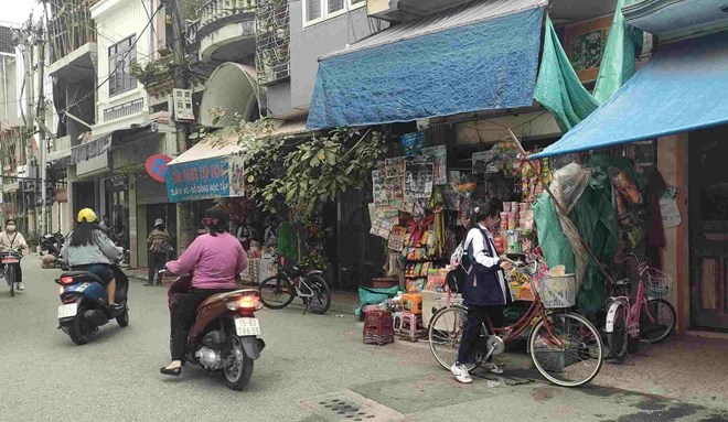 Nhiều hàng quán bày bán bánh kẹo ở khu vực cổng trường THCS Quang Trung. Ảnh: LĐO