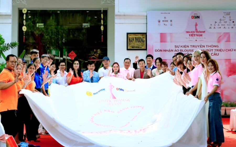 Mọi người đồng lòng ký khai bút trên chiếc áo Blouse Phá kỷ lục với tổng  diện tích hơn 80m2 thể hiện tinh thần chung tay bảo vệ sức khỏe - sắc đẹp cộng đồng Việt Nam