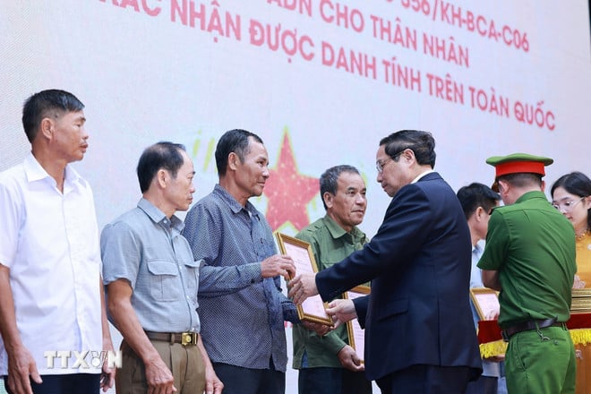 Thủ tướng Phạm Minh Chính trao thông báo kết quả giám định ADN hài cốt liệt sỹ cho đại diện gia đình liệt sỹ. (Ảnh: Dương Giang/TTXVN)