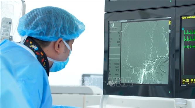 Bác sĩ Bệnh viện FV quan sát hình ảnh các mạch máu não quanh khối u trong quá trình làm tắc mạch. Ảnh: TTXVN phát