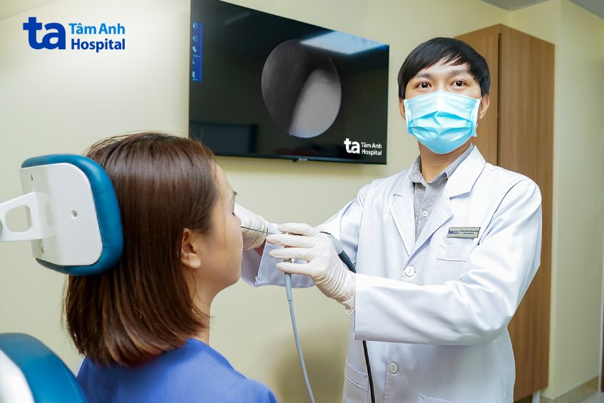 Bác sĩ Minh nội soi mũi cho chị Thương. Ảnh: Bệnh viện Đa khoa Tâm Anh.