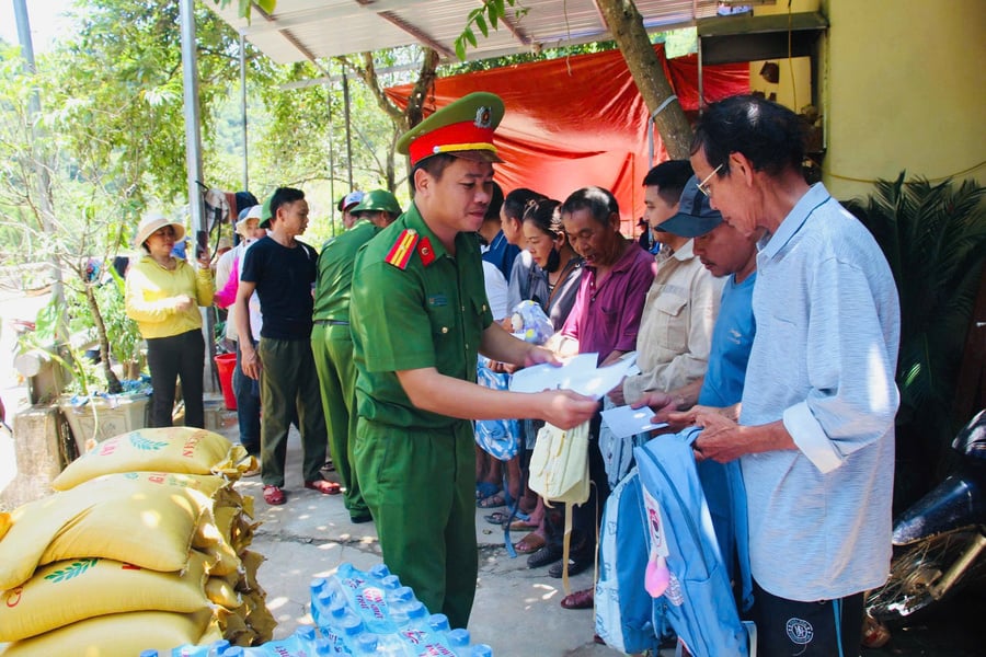 Thiếu tá Nguyễn Đăng Thanh, Trưởng Công an xã Quan Thành đại diện đoàn trao tặng những phần quà cho các gia đình bị thiệt hại nặng tại bản Cửa Rào 2, xã Tương Dương