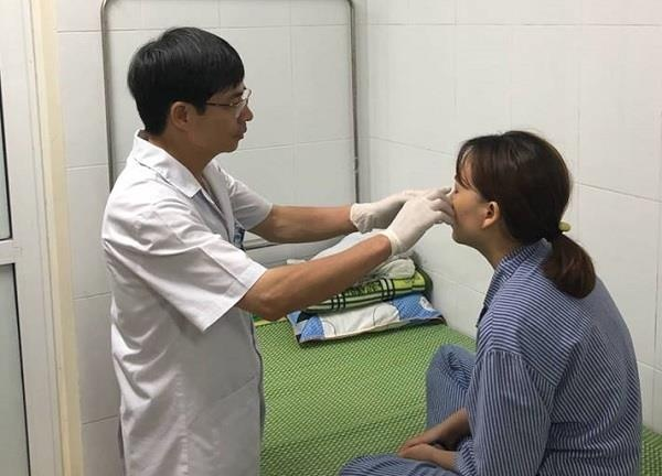 
TS.BS Phạm Cao Kiêm đang điều trị cho bệnh nhân Đoàn Thị M. Ảnh: B.LOAN
