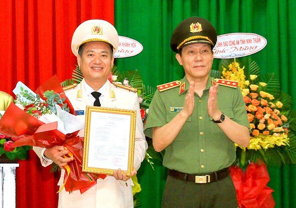 Thượng tướng Lương Tam Quang trao quyết định của Bộ Công an điều động, bổ nhiệm đại tá Nguyễn Thế Hùng (trái) làm giám đốc Công an tỉnh Khánh Hòa - Ảnh: Tuổi trẻ