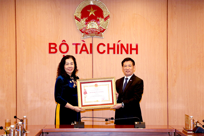 Thừa ủy quyền của Chủ tịch nước, Bộ trưởng Bộ Tài chính Hồ Đức Phớc trao tặng Huân chương Lao động hạng Nhất cho Thứ trưởng Vũ Thị Mai.