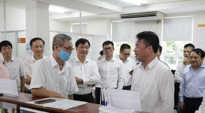 Tổng Giám đốc Nguyễn Thế Mạnh trao đổi với người dân đến làm việc qua tính năng đặt lịch làm việc trực tuyến tại bộ phận Một cửa BHXH Tp.HCM.
