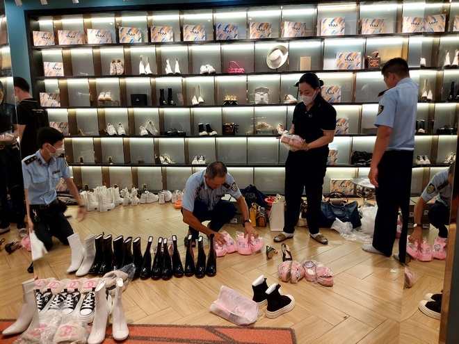 Lực lượng QLTT tiến hành kiểm tra các sản phẩm thời trang bày bán tại Shop Trang Nemo. Ảnh: DMS.