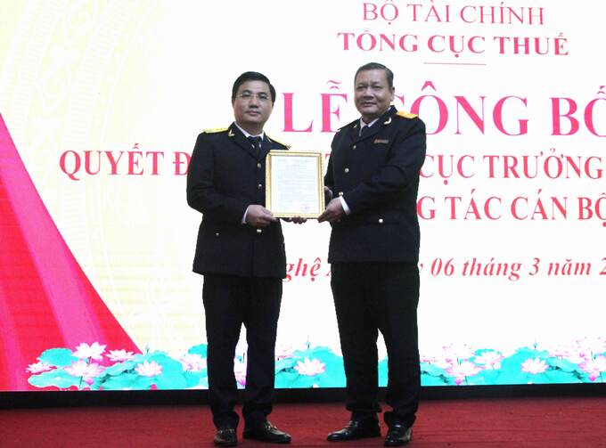 Phó Tổng cục trưởng Tổng cục Thuế Phi Vân Tuấn (bên phải) trao quyết định cho ông Nguyễn Đình Đức.