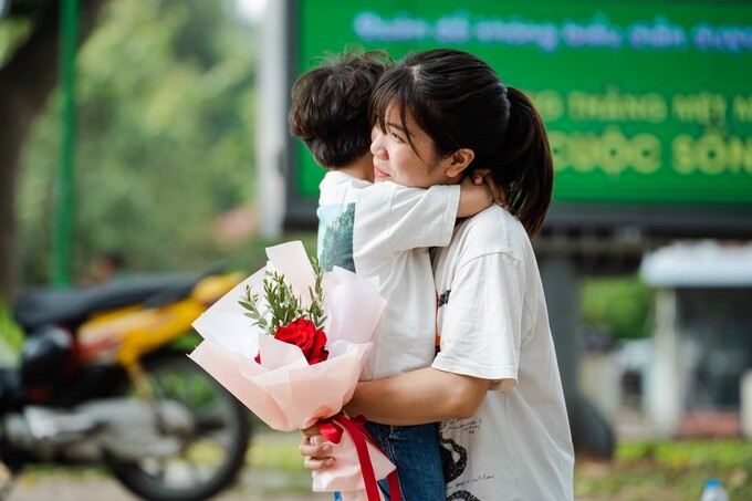 Một bà mẹ rung rung xúc động khi được nhận hoa và cái ôm từ con.