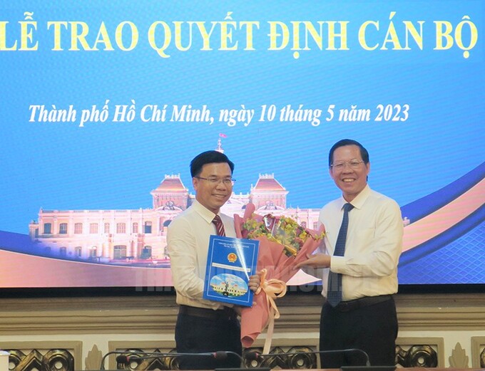 Chủ tịch UBND Tp.HCM Phan Văn Mãi trao quyết định và tặng hoa chúc mừng Tân Phó Giám đốc Sở KH-ĐT Phạm Trung Kiên (Ảnh: Thành ủy Tp.HCM)