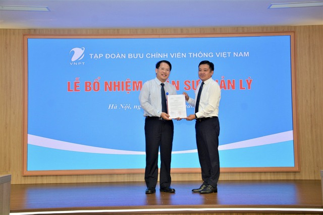Ông Nguyễn Văn Tấn (bên trái) nhận quyết định Tổng giám đốc Tổng công ty VNPT VinaPhone. Ảnh: Báo Thanh niên