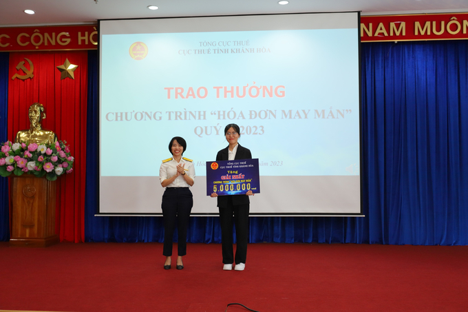 Bà Nguyễn Kim Thái Linh, Phó cục trưởng Cục Thuế Khánh Hòa trao giải nhất cho bà Lê Thị Minh Loan.