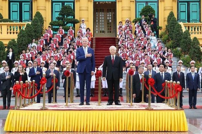 Tổng Bí thư Nguyễn Phú Trọng và Tổng thống Hoa Kỳ Joe Biden trên bục danh dự, thực hiện nghi thức chào cờ. (Ảnh: TTXVN)
