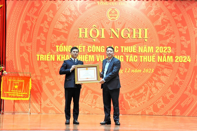 Thứ trưởng Bộ Tài chính Cao Anh Tuấn trao Bằng khen của Thủ tướng Chính phủ cho ông Vũ Chí Hùng, Phó tổng cục trưởng Tổng cục Thuế.