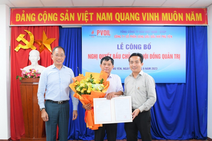 Ông Cao Hoài Dương - Bí thư Đảng ủy, Chủ tịch HĐQT PVOIL (bên trái) và Ông Ngô Văn Nhiệm - Giám đốc PVOIL Phú Yên (bên phải) trao Nghị quyết và tặng hoa chúc mừng ông Nguyễn Mậu Dũng.