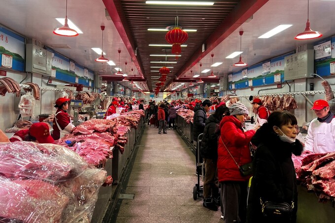 Người bán thịt phục vụ khách hàng tại chợ bán buôn Xinfadi ở Bắc Kinh, Trung Quốc ngày 2/2/2024. Ảnh: Reuters
