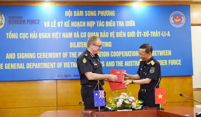 Tổng cục trưởng Nguyễn Văn Cẩn và ông Michael Outram - Cao ủy Cơ quan Bảo vệ biên giới Australia trao Kế hoạch hợp tác điều tra.