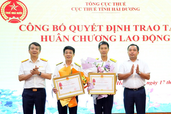 Tổng cục trưởng Mai Xuân Thành và Bí thư Tỉnh ủy Hải Dương Trần Đức Thắng trao Huân chương Lao động cho các cá nhân có thành tích xuất sắc trong công tác thuế. (Ảnh: Tổng cục Thuế)