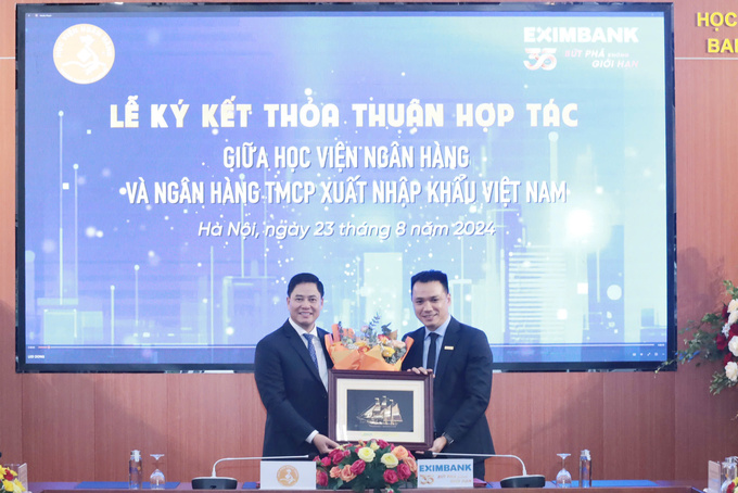 Ông Nguyễn Cảnh Anh - Chủ tịch Hội đồng quản trị Eximbank (bên phải) trao tặng quà lưu niệm tại buổi Lễ cùng với PGS.TS. Bùi Hữu Toàn - Bí thư Đảng ủy, Chủ tịch Hội đồng Học viện Ngân hàng (bên trái).